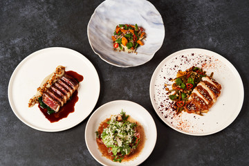 Set of various plates of food on a gray table background with copy space