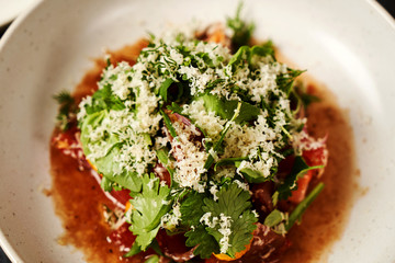 Fresh vegetable salad in a white plate on dark table background