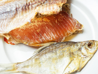 River fish with delicious caviar lies on a white plate