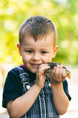 Portrait of little boy with chick outdoors at the day time. Concept of happy life.