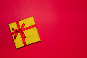 gift box with a red bow on a red background. holiday concept, for example, Valentine's Day, women's day. the concept of love and feeling. gift. space for text. the view from the top.
