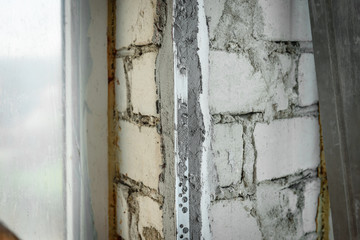 The plasterer repairs the corners of the window with a spatula and plaster. Construction finishing works.