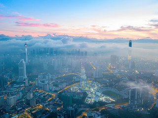 Aerial view of sunrise at Kuala Lumpur city skyline with low clouds