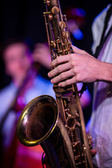 Man holding saxophone with bassist in background