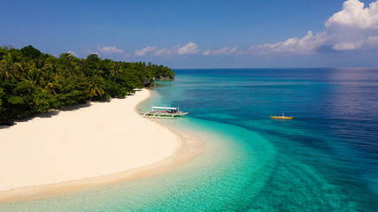 Seascape with a beautiful tropical island, aerial view. Mahaba Island, Philippines. Blue sea with turquoise lagoons. Summer and travel vacation concept.