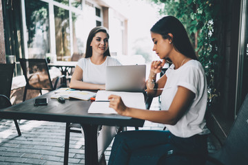 Female partners working remotely together outdoors