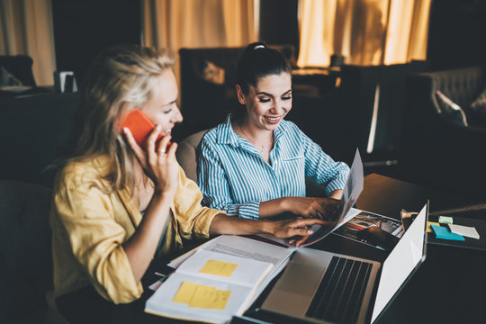 Female freelancers analyzing graphs in cafe