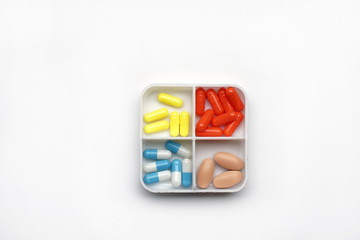 miscellaneous medicine in a health container. multicolored capsules and tablets