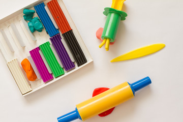 Fototapeta premium plasticine. dough for modeling. leisure and creativity for children. Concept of children's activities. Top view of multi-colored clay and tools for needlework.