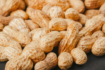 Peanuts in the shells on the black slate stone