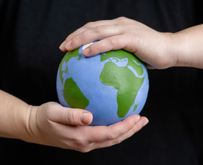 Close up woman holds planet in hands. Ecology concept. Isolated on dark background