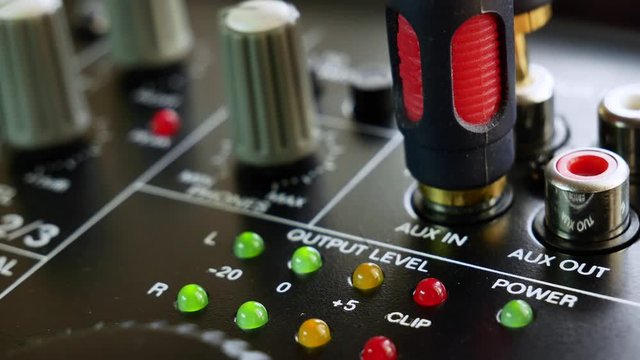 Plug the RCA cinch plugs in the analogue audio mixer. Close up 4k