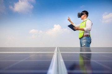 Fototapeta na wymiar Engineer using vr helmet for checking commissioning and test run solar system, on a photovoltaic panels.Renewable energy concepts.