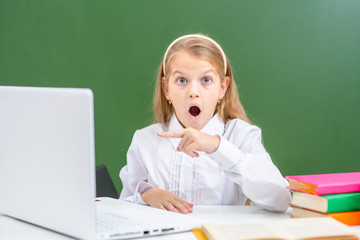 Shocked girl points on screen of the laptop. Internet safety concept