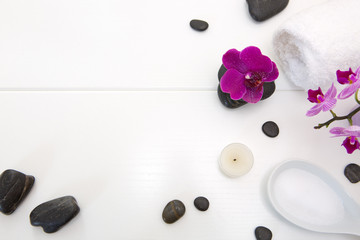 Obraz na płótnie Canvas Spa setting with pink orchids , black stones and candle on white background.