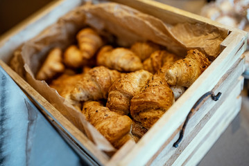 Wooden basket full of tasty croissants.