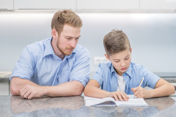 Fototapeta premium Father helps his son doing homework at home