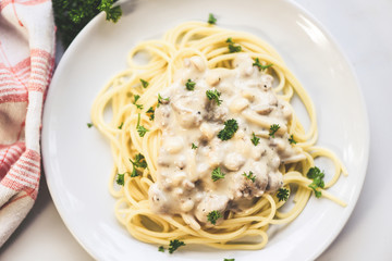 Spaghetti italian pasta served on white plate with parsley in the restaurant italian food and menu concept - spaghetti carbonara top view