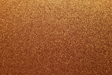 Golden shiny background, yellow sparkles, brown grainy texture. Material pattern, metallic tinsel, decoration.