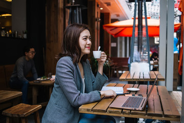 Young woman smiling while drinking coffee