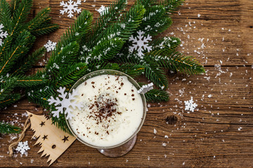 Traditional prune dessert with nuts and whipped sour cream with sugar. New Year's sweet treat concept. Wooden boards background