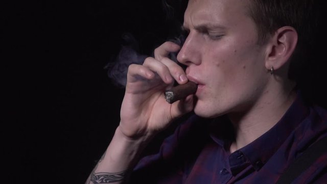 The guy's smoking a cigar. Close-up. Slow motions 120 fps