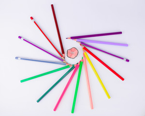 Naklejka premium Bunch of crayons and pencils circling a pencil shaving in an isolated white background