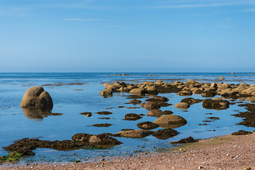 Normandy, France. Beautiful beach with boulders reflected in calm water.  Majestic nature background. Eco-planet concept.