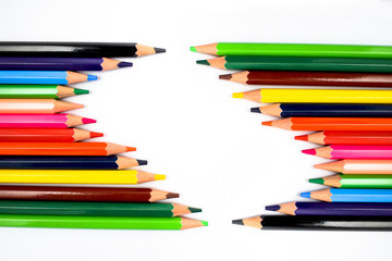 Close up picture of two rows of color pencils facing each other in a wave formation