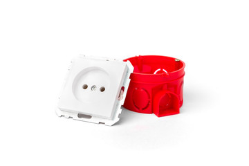 Red installation electric box for sockets and white socket and wires on concrete background.