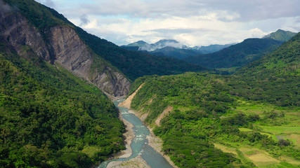 Fototapeta na wymiar Mountains covered by rainforest, aerial view. River in a mountain gorge. Cordillera on Luzon Island, Philippines. Summer and travel vacation concept.