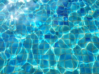 Surface of Water in swimming pool with sun reflection