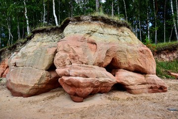 Veczemju klintis, a group of sand cliffs on the Vidzeme coast, red, orange and yellow formations, a sandy beach on the seashore, trees on a hilltop, a beach in Latvia on the shore of the Gulf of Riga.