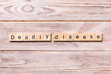 deadly disease word written on wood block. deadly disease text on wooden table for your desing, coronavirus concept top view