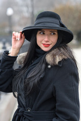 A nice girl in a beautiful gray coat and hat walks in the park on a cold autumn / winter day. Portrait photography.
