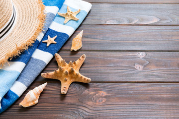 Straw hat, blue towel and starfish On a dark wooden background. top view summer holiday concept with copy space