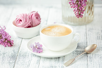 Obraz na płótnie Canvas Bouquet of lilacs, cup of coffee, homemade marshmallow Romantic spring morning Selective focus