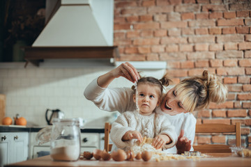 Mother and daughter baking cookies in their kitchen
