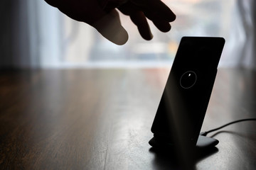 smartphone wireless charging on charging stand on wooden table