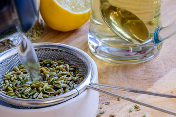 fennel seeds inside sieve being brewed for healthy drink