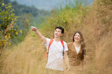 asian couple travel walking on gold meadow. beautiful man and woman lovely, happiness.