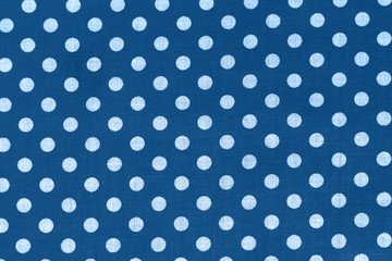 Polka dot on classic blue canvas cotton texture. Blue fabric with printed white circles. Bright colored cotton background