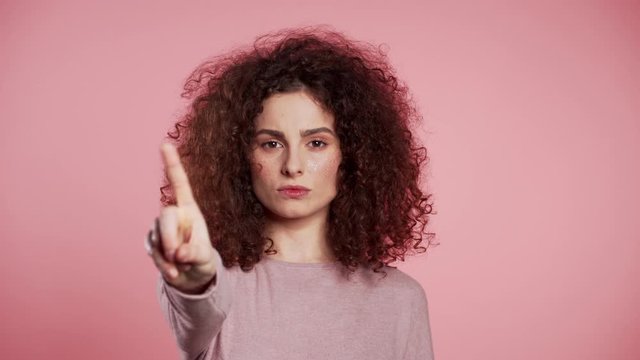 Pretty girl disapproving with no crossing hands sign make negation gesture. Denying, Rejecting, Disagree, Portrait of woman on pink background.