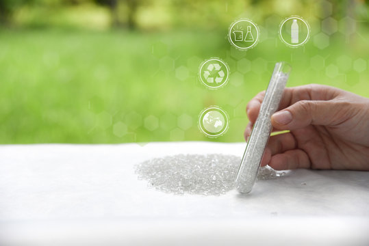 Hand holding Pet polyester chips,Plastic pet polyester chips,Chips bright in test tube with Test icon,recycle icon,Global icon&Bottle icon.Chemical concept
