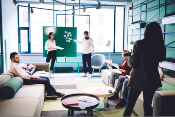 Work partners having conversation in hall of workplace