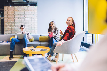 Young modern coworker sitting in office lounge room