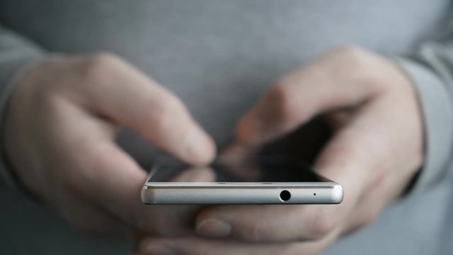 Two Male hands fast texting sms message on mobile phone