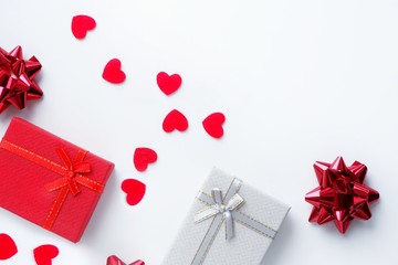 Gift boxes, bows and red hearts on a white background. Valentine's day concept, love, romance, congratulations, holiday. Top view, flat lay, copy space for text.