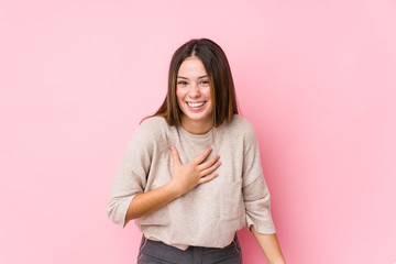 Young caucasian woman posing isolated laughs happily and has fun keeping hands on stomach.