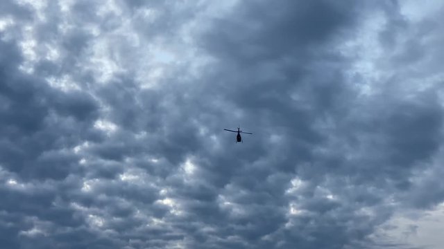 Helicopter flying over the sea. View from the ground